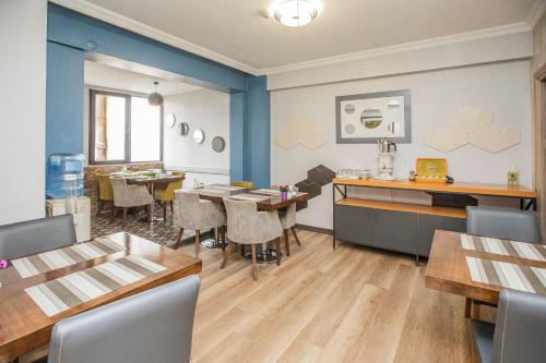 uma sala de jantar com paredes azuis e mesas e cadeiras em Konuk Hotel em Eskisehir