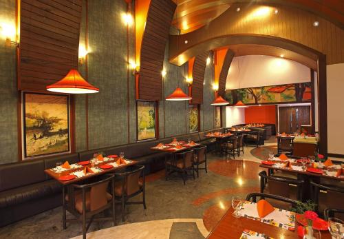 a dining room with tables and chairs in a restaurant at Hotel Aurora Towers in Pune