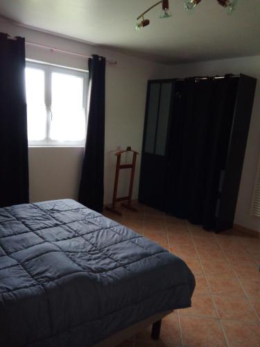 a bedroom with a bed and black curtains and a window at Les Gîtes de Brives in Brives-sur-Charente