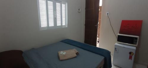 una piccola camera con un letto e un tovagliolo sopra di Pelinca Square Center a Campos dos Goytacazes