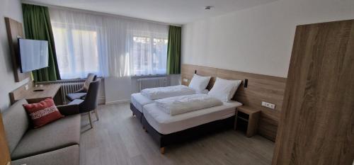 ein Hotelzimmer mit einem Bett und einem Stuhl in der Unterkunft Hotel Ladage in Frankfurt am Main