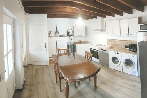 une cuisine avec une table et des chaises dans une pièce dans l'établissement Les cloches de la Haye, à La Haye-Pesnel