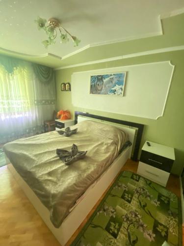a bedroom with a bed with a flower on it at Просторі та комфортні апартаменти «Д.І.М.» in Kamianets-Podilskyi