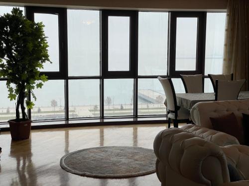 a living room with a table and chairs and a large window at Park Azure Residence in Baku