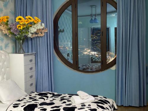 a bedroom with a mirror and a bed and a vase of flowers at Park Azure Residence in Baku