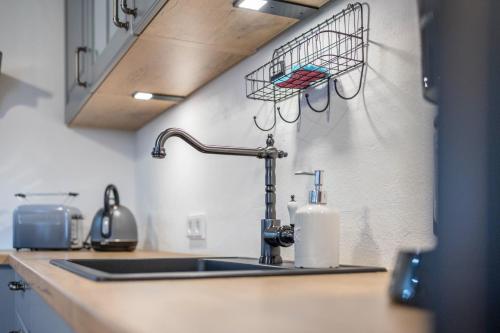 um balcão de cozinha com um lavatório e uma cesta na parede em Wohnung Sunntratn em Gaißach