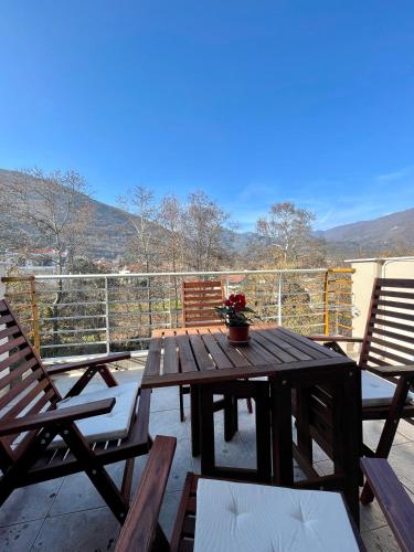 a wooden table and chairs on a deck with a view at Hilltop Lodge Orma in Órma