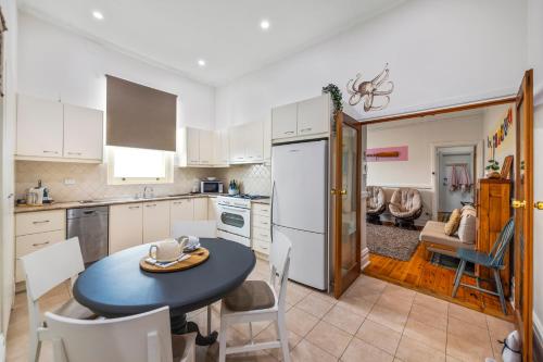 a kitchen with a table and a kitchen with a dining room at Kerrigan's on Seaview- one minute walk to beach - not beachfront in Henley Beach
