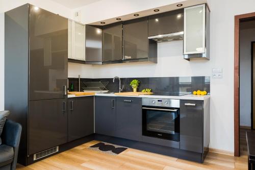 a kitchen with gray cabinets and a sink and a dishwasher at ShortStayPoland Grodkowska (B114) in Warsaw