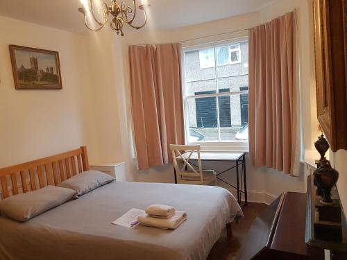 a bedroom with a bed and a desk and a window at Cozy Place in Oxford