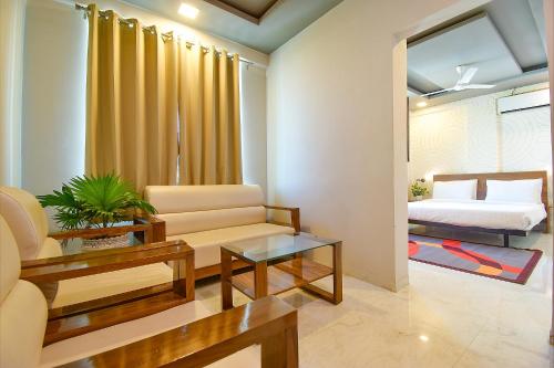 a living room with a couch and a bed at FabHotel Manomay Homes - Nr Manish Nagar in Nagpur