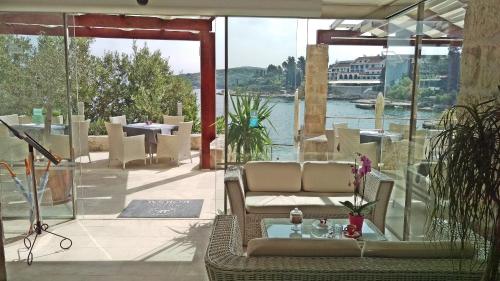 a patio with a couch and chairs and a view of the water at Hotel Korsal in Korčula