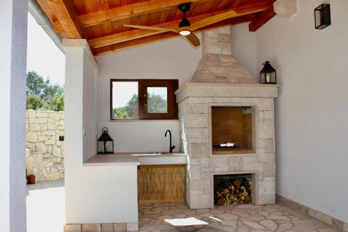a kitchen with a stone fireplace and a ceiling at Villa Bora - Ferienhaus am Meer in Slatine