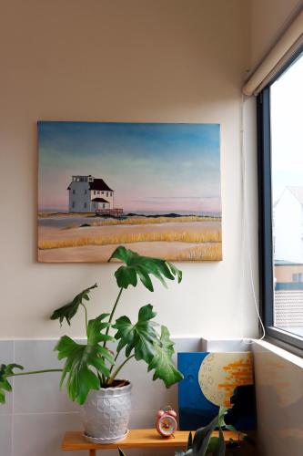 a painting of a house and a plant on a wall at Anita homestay Dalat in Khu Chi Lăng