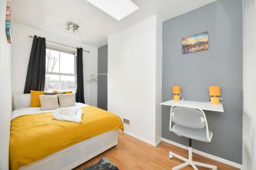 a bedroom with a yellow bed and a desk at Impeccable 4-Bed House in Brixton London in London