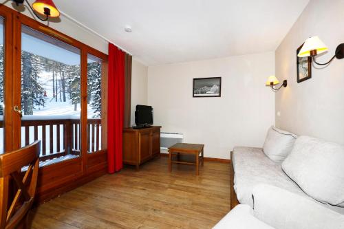 un salon avec un canapé et une fenêtre dans l'établissement Appartement Résidence Albane Vars, à Vars