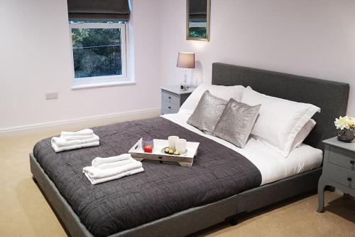 a bedroom with a bed with a tray of towels at New Ground floor apartment, 4 mins walk to beach in Bournemouth