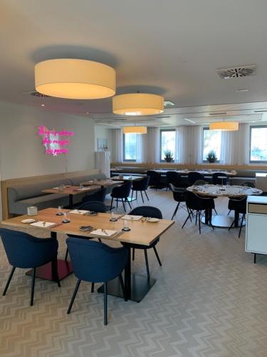 a dining room with tables and chairs and windows at Gasthof zum Bad in Langenau