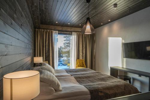 Un dormitorio con una cama grande y una ventana en Ski-Inn Kultakero en Pyhätunturi