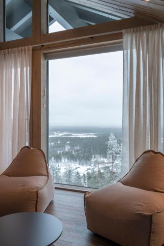 a living room with a large window and a couch at Ski-Inn Kultakero in Pyhätunturi