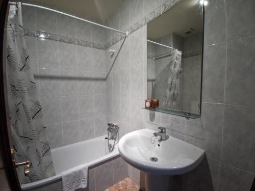 a bathroom with a sink and a shower and a tub at Apartamentos Bricia in Posada de Llanes