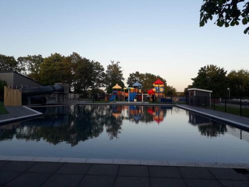 een zwembad met een speeltuin en een waterglijbaan bij Ferienhaus / Chalet / Bungalow am See, Holland, Niederlande, Lathum in Lathum