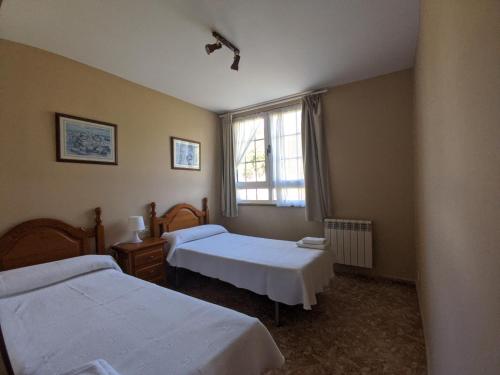 a room with two beds and a window at Apartamentos Bricia in Posada de Llanes