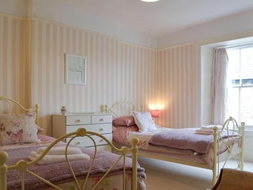 a bedroom with two beds and a window at Gilmore House in Alston