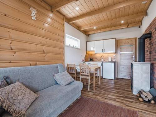 a living room with a couch and a kitchen at Domki Wichrowe Wzgórze Bieszczady in Bukowiec