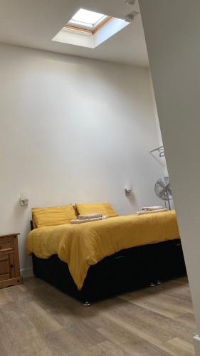 a large bed in a room with a window at Deepcut Lodge Bed & Breakfast Self Service in Camberley