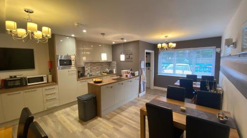 cocina y comedor con mesa y sillas en Deepcut Lodge Bed & Breakfast, en Camberley