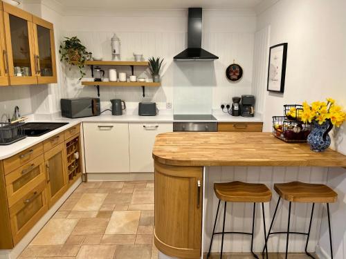 a kitchen with a counter and stools in it at Hollyhocks Holiday Home-Luxury ground floor 2 bedroomed apartment sleeps 5 in Ivybridge