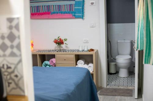 a small bathroom with a bed and a toilet at House of Love in Pardes H̱anna
