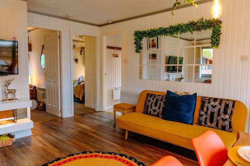 un soggiorno con divano e specchio di Wooden Cosy Retreat Hunters Quay a Dunoon