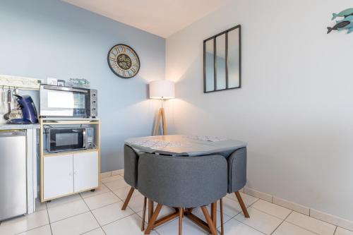 a small kitchen with a table and a microwave at La Rose des Sables in Tréffiagat