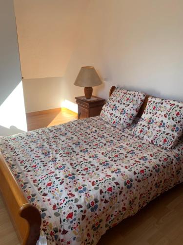 - une chambre avec un lit et une couette à fleurs dans l'établissement GITE CENTRE ALSACE, à Barr