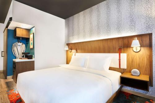 a bedroom with a large white bed and a window at Hyatt Centric Downtown Denver in Denver