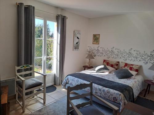 a bedroom with a bed and a chair and a window at Chambre d'Elisabeth à la Ferme in Montépilloy