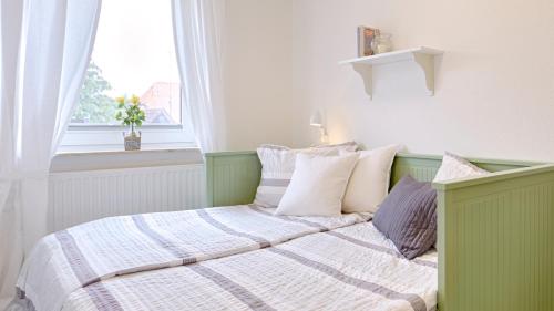zielone i białe łóżko w pokoju z oknem w obiekcie Ferienwohnung Zollstraße 1. Etage w mieście Bleckede