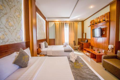 a hotel room with two beds and a television at Lien Do Star Hotel in Bảo Lộc