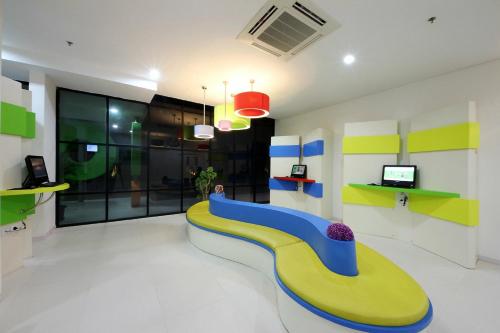 a room with a yellow and blue bench in the middle at POP! Hotel Airport Jakarta in Tangerang