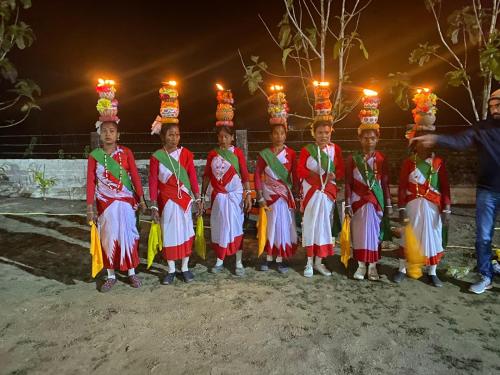 a group of children in traditional dress posing for a picture at Chocolate Inn Rainforest Resort & Spa in Jalpāiguri