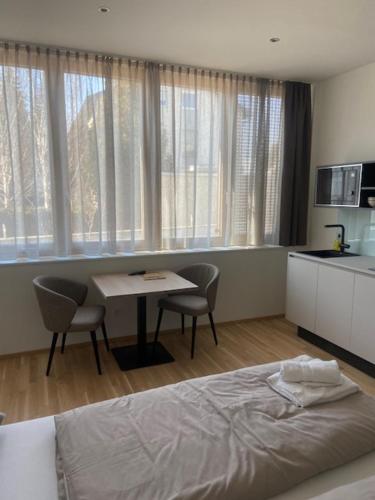 Schlafzimmer mit einem Bett und einem Tisch mit Stühlen in der Unterkunft LOOMZ living Self-check-in in Innsbruck