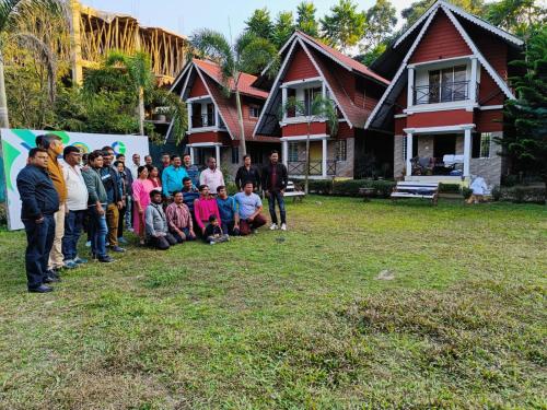 a group of people standing in front of a house at Chocolate Inn Rainforest Resort & Spa in Jalpāiguri