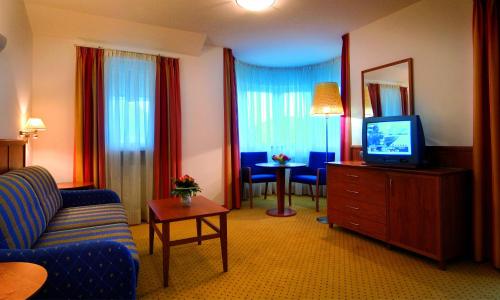 une chambre d'hôtel avec un canapé et une télévision dans l'établissement Hotel Millanderhof, à Bressanone