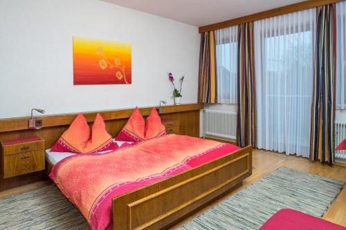 a bedroom with a large wooden bed with red pillows at Gasthof Dangl in Wimpassing an der Pielach