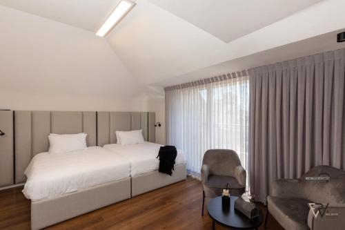 um quarto com uma cama, uma cadeira e uma janela em Shirat Haneviim-Luxury Penthouse #Rental Israel em Jerusalém
