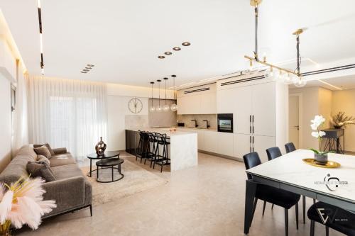 uma sala de estar e cozinha com um sofá e uma mesa em Shirat Haneviim-Luxury Penthouse #Rental Israel em Jerusalém