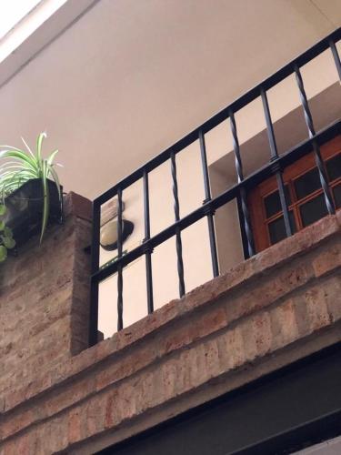 a balcony with a window and a potted plant on it at Derby Home Hotel in Buenos Aires