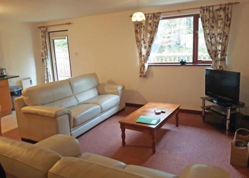 a living room with a couch and a coffee table at Avalon Cottages in Llangynin